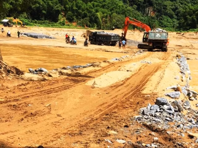 Tạo thành mặt đường cho xe chở vật liệu vượt sông Luồng vào bản Sa Ná.