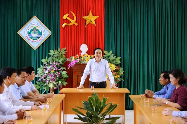 Bộ trưởng nói chuyện với cán bộ, giáo viên nhà trường. Ảnh: Xuân Phú