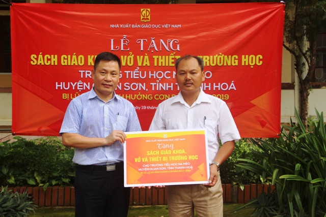 Thầy giáo Chung Trường Thành - Hiệu trưởng Trường Tiểu học Na Mèo nhận quà tặng từ Nhà xuất bản GDVN.