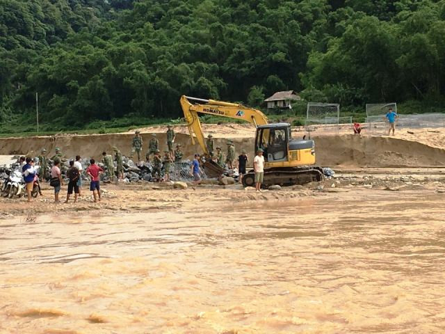 Dùng máy múc gạt cát, tạo mặt bằng đổ đá.