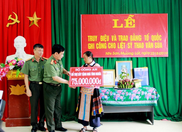Thay mặt lãnh đạo Bộ Công an, đại tá Đào Đức Minh - Phó Giám đốc Công an tỉnh Thanh Hóa trao số tiền 75 triệu đồng, để hỗ trợ gia đình liệt sĩ Thao Văn Súa làm nhà tình nghĩa.