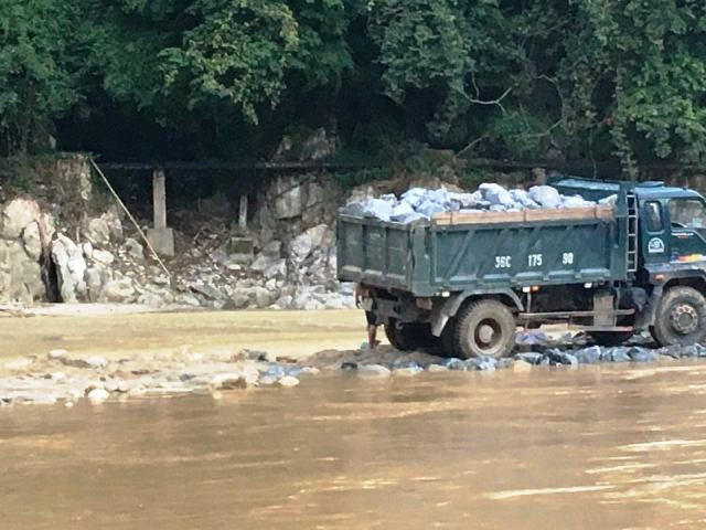Đưa đá hộc xuống tạo nền móng đường dẫn.