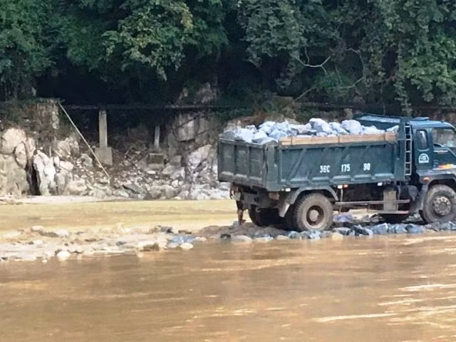 Đưa đá hộc xuống tạo nền móng đường dẫn.