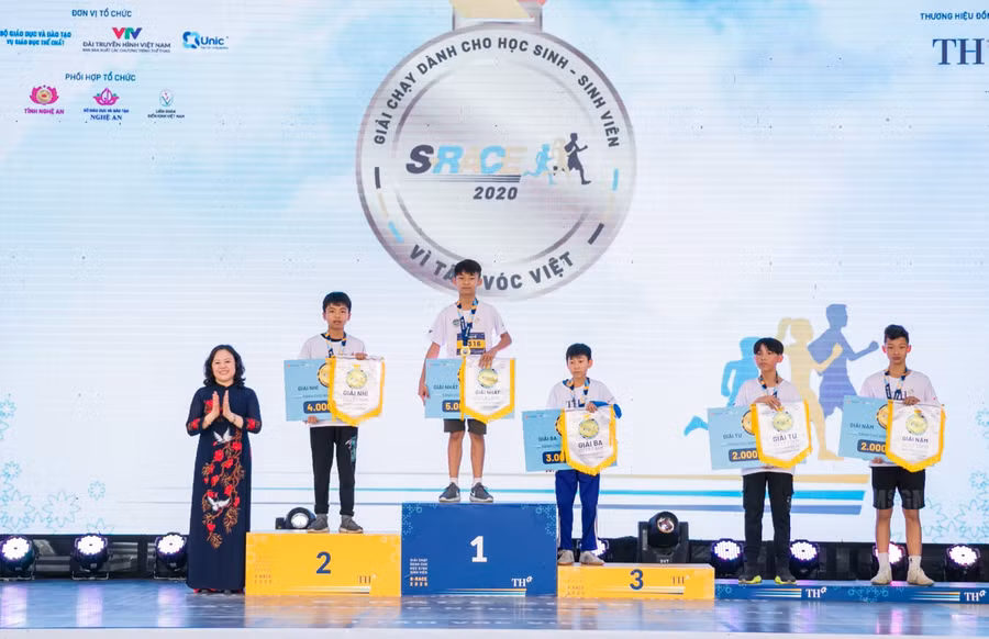 Thứ trưởng Ngô Thị Minh trao thưởng cho tốp 5 vận động viên về đích nội dung chạy 1,5km học sinh nam THCS.