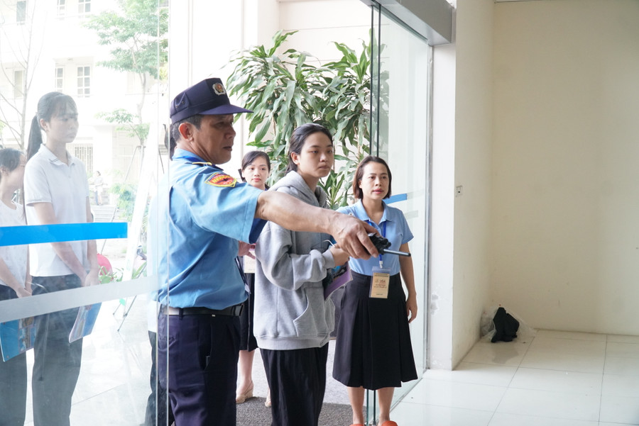 Các bộ phục vụ thi được hướng dẫn thí sinh trước khi vào phòng thi. Ảnh: Hồ Lài