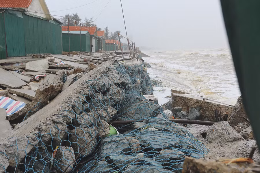 Dưới chân kè, những mảng bê tông bị sóng đánh hở hoác hết chân đế, các rọ đá cũng bị xiêu vẹo.