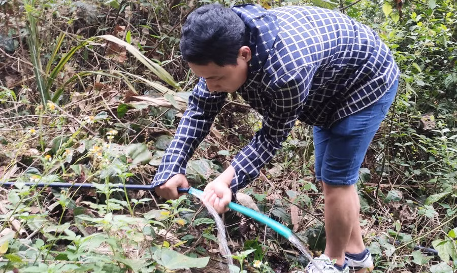 Thầy Quý sửa chữa một đoạn ống nước của dân bản bị bung ra ở trong rừng. (Ảnh: Thế Lượng)