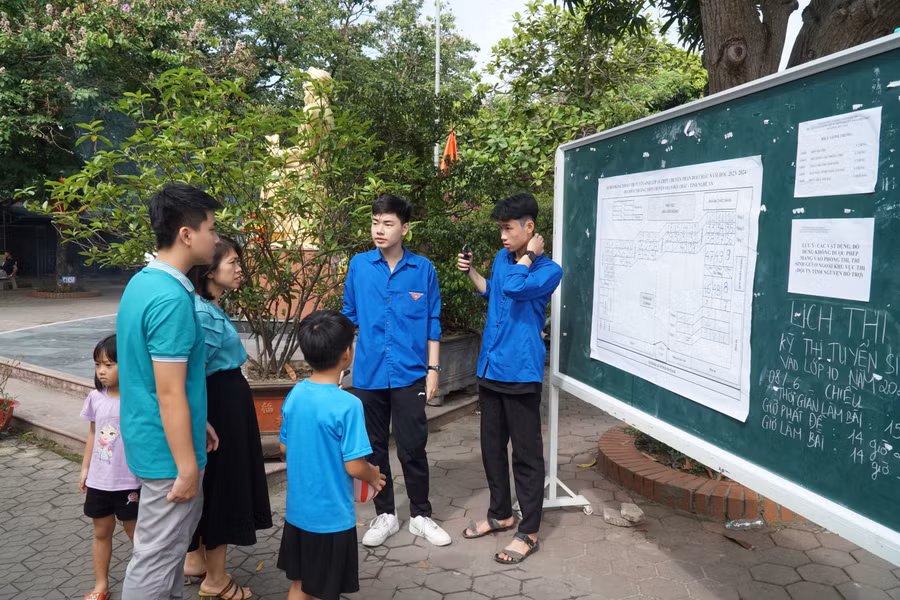 Đội tình nguyện viên hướng dẫn thí sinh và phụ huynh xác định đúng vị trí phòng thi. Ảnh: Hồ Lài.