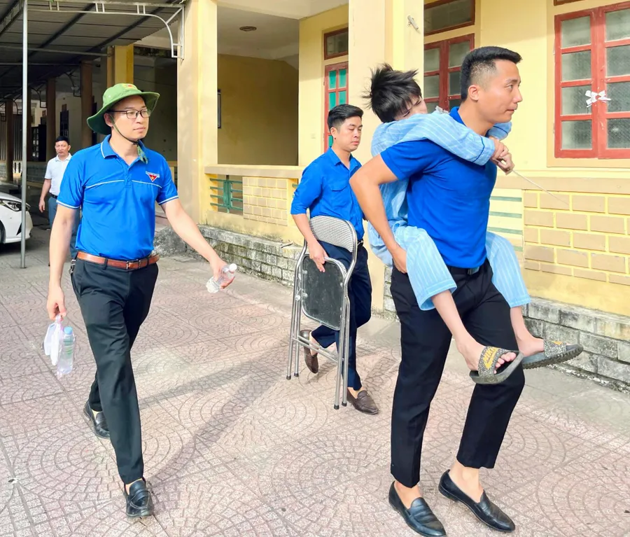 Em Nguyễn Văn Tú được thanh niên tình nguyện đưa vào phòng thi tại Hội đồng thi Trường THPT Đô Lương 1 (huyện Đô Lương, Nghệ An). Ảnh: NTCC