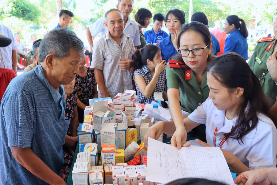 Cấp phát thuốc và tặng quà cho người dân.