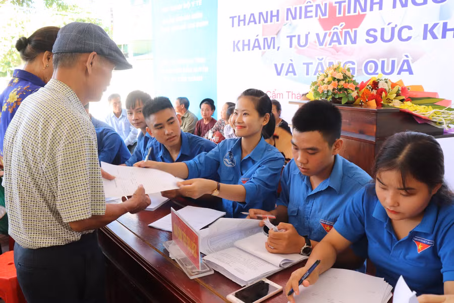 Thanh niên tình nguyện đang hướng dẫn cho người dân thủ tục khám sức khỏe.