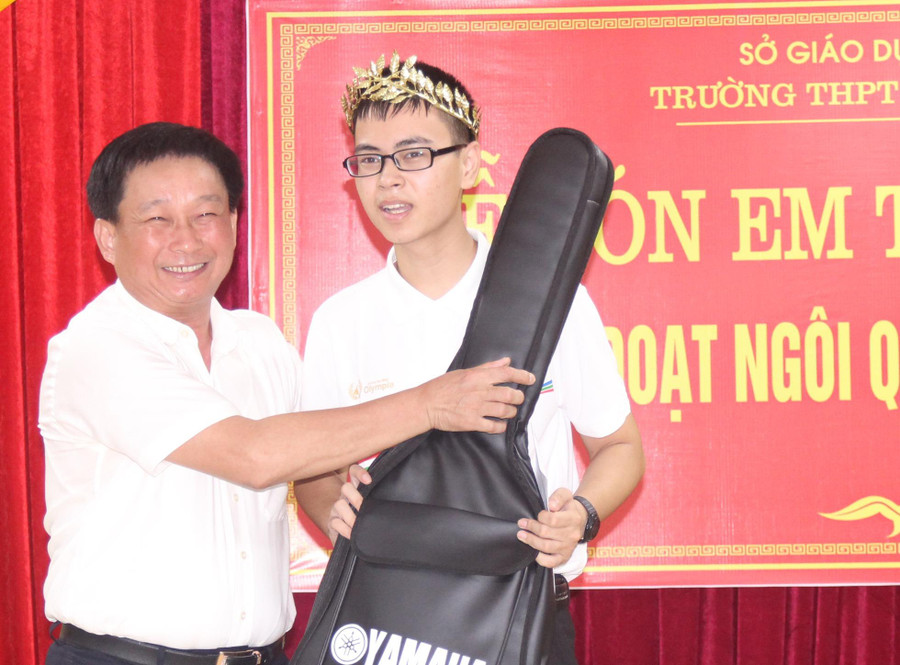 Thầy Ngô Sỹ Thủy - Hiệu trưởng nhà trường tặng em Trần Thế Trung cây đàn mà em yêu thích.