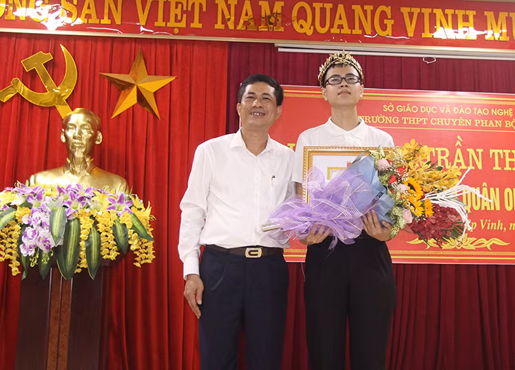 Ông Thái Văn Thành - Giám đốc Sở GD&ĐT Nghệ An trao giấy khen và phần thưởng cho em Trần Thế Trung.