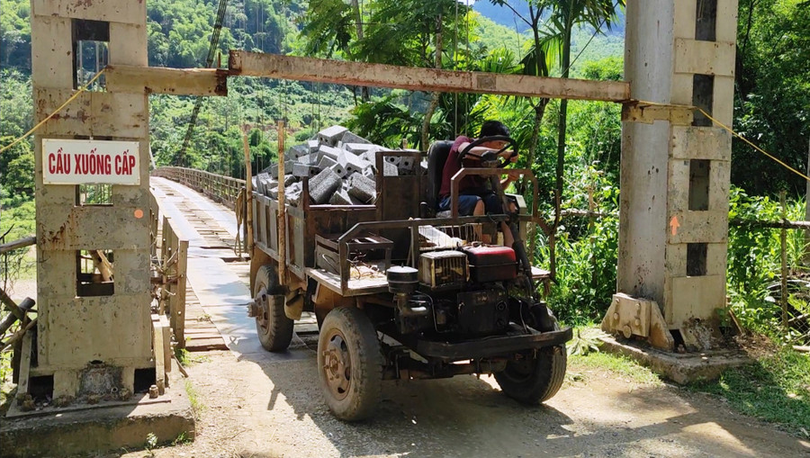 Người dân chở vật liệu xây dựng bằng xe công nông qua cầu treo Chiềng, xã Phú Sơn, (Quan Hóa, Thanh Hóa) trong tình trạng 'nơm nớp lo sợ. Ảnh: Thế Lượng.