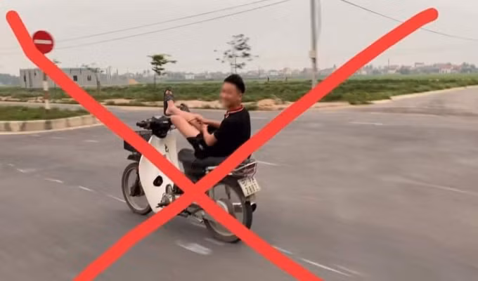 Hình ảnh nam thanh niên dùng 2 chân lái xe máy.