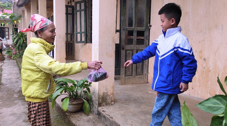 Bà đưa cơm cho cháu ở điểm trường lẻ bản Tân Sơn - Trường Tiểu học Thanh Xuân, xã Phú Xuân (Quan Hóa, Thanh Hóa). Ảnh: Thế Lượng.