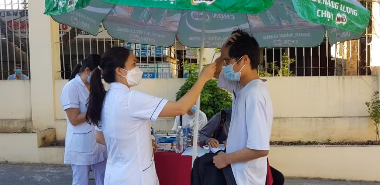 Thí sinh được kiểm tra thân nhiệt trước khi vào phòng thi. Hình ảnh tại Hội đồng thi Trường THPT Trần Phú
