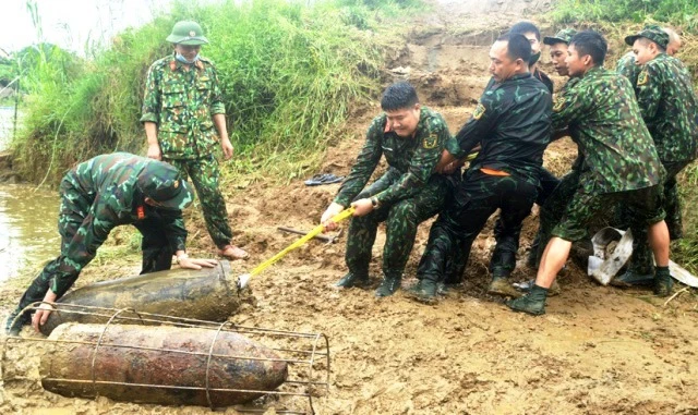 Cán bộ, chiến sỹ Đại đội Trinh sát, Bộ CHQS tỉnh trục vớt bom từ bờ sông Lô lên bờ. Ảnh: Báo Tuyên Quang.