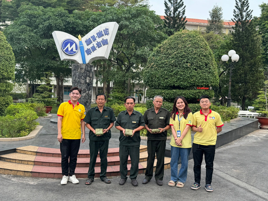 Các chú bảo vệ của trường nhận chiếc bánh chưng từ sinh viên. Ảnh: UFM Các chú bảo vệ của trường nhận chiếc bánh chưng từ sinh viên. Ảnh: UFM