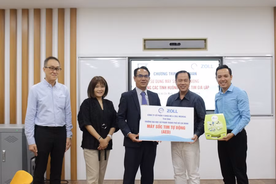 Đại diện ZOLL Medical và Công ty Cổ phần Y Khoa NQ lên trao bảng tượng trưng máy sốc tim tự động AED cho Trường Đại học Sư phạm TPHCM. Ảnh: NTCC