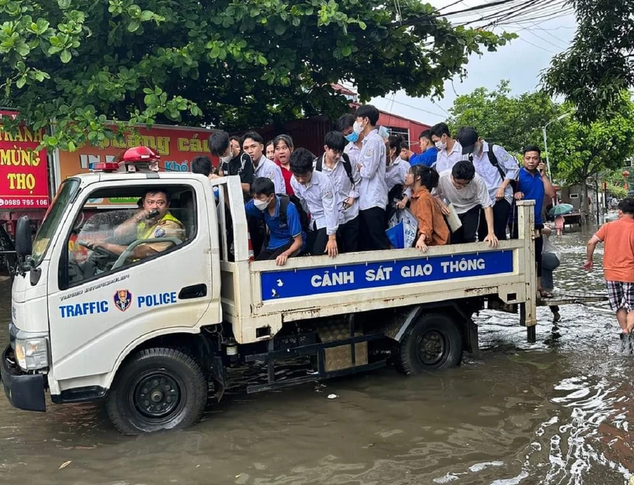 CSGT huyện Cẩm Khê dùng xe chuyên dụng đưa thí sinh vào điểm thi bị ngập úng.