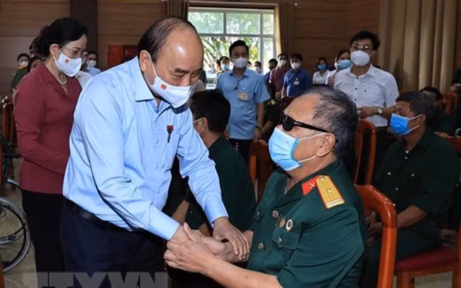 Chủ tịch nước Nguyễn Xuân Phúc thăm hỏi thương bệnh binh tại Trung tâm nuôi dưỡng bệnh binh nặng và Điều dưỡng người có công tỉnh Hà Nam. Ảnh: TTXVN.