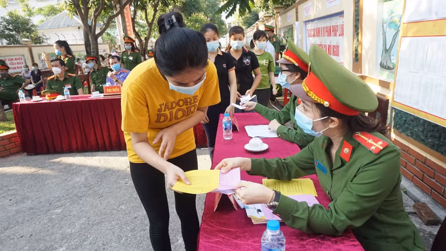 Cán bộ chiến sĩ công an giao phiếu bầu cử và hướng dẫn bị can thực hiện đúng trình tự để phiếu bầu hợp lệ.