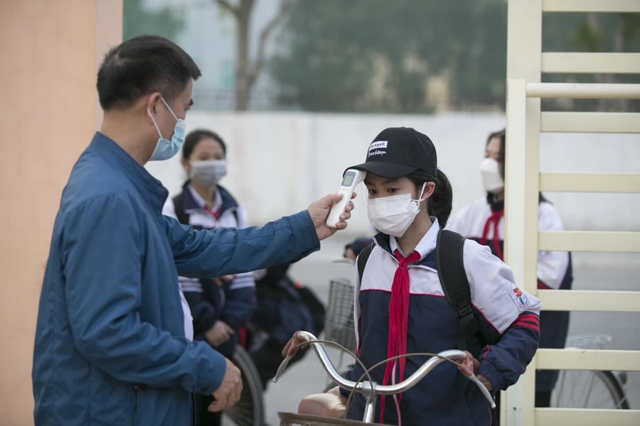 Đo thân nhiệt cho học sinh lớp 9 tại Trường THCS Quán Bàu (TP Vinh, Nghệ An).