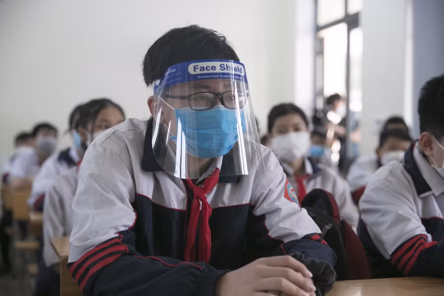 Việc cho học sinh các khối 9, 10, 11 của TP Vinh đi học trở lại được thực hiện sau khi khối 12 đến trường trực tiếp 1 tuần trước đó. Các em đến lớp thực hiện đầy đủ biện pháp phòng dịch. Một số bạn ngoài đeo khẩu trang còn đeo cả kính chống giọt bắn.