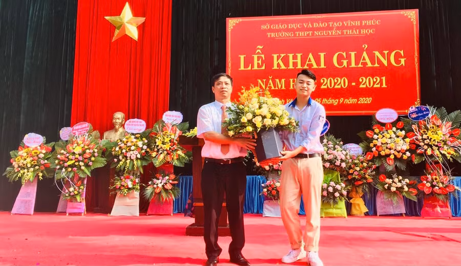 Thầy Lê Anh Tuấn nhận hoa chúc mừng của đại diện học sinh trường THPT Nguyễn Thái Học