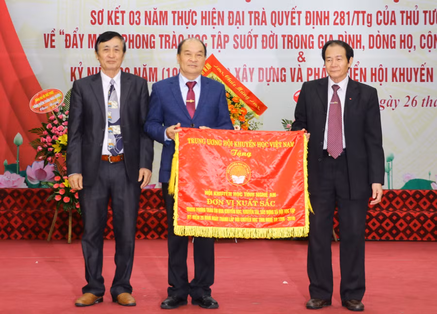 Ông Phạm Hoàng Be, Phó Chủ tịch Trung ương Hội Khuyến học Việt Nam trao cờ thi đua xuất sắc cho Hội khuyến học tỉnh Nghệ An