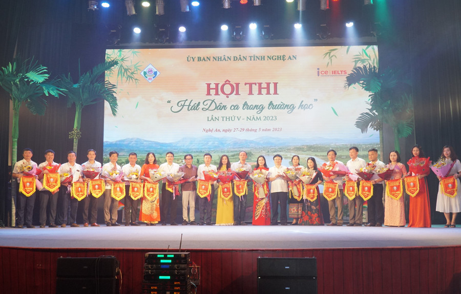 Ông Bùi Đình Long - Phó Chủ tịch UBND tỉnh Nghệ An và đại diện Ban tuyên giáo tỉnh ủy trao cờ lưu niệm cho các đơn vị tham gia hội thi. Ảnh: Hồ Lài.