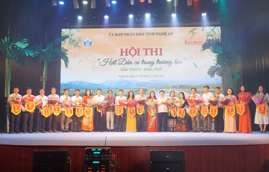 Ông Bùi Đình Long - Phó Chủ tịch UBND tỉnh Nghệ An và đại diện Ban tuyên giáo tỉnh ủy trao cờ lưu niệm cho các đơn vị tham gia hội thi. Ảnh: Hồ Lài.