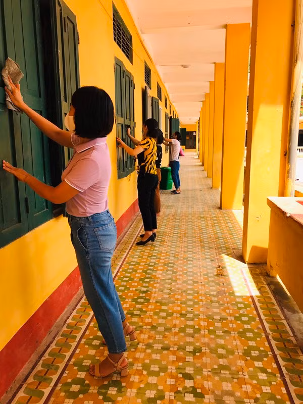 Giáo viên làm vệ sinh bên ngoài lớp học tại Trường THPT Nguyễn Viết Xuân.