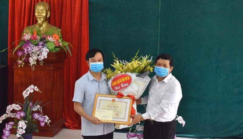 Ông Nguyễn Văn Mạnh - Giám đốc Sở GD&ĐT Phú Thọ trao bằng khen của Bộ trưởng Bộ Giáo dục và Đào tạo cho thầy Phùng Anh Tuấn. Ảnh: Hà Trang