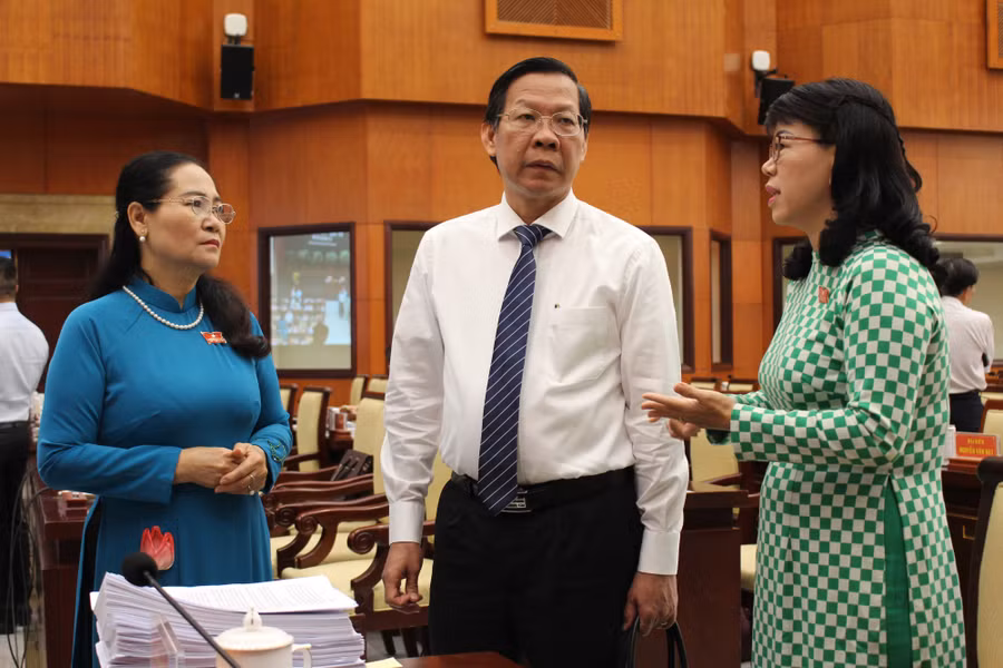 Chủ tịch UBND TPHCM Phan Văn Mãi (giữa) trao đổi với các đại biểu bên lề hội nghị. (Ảnh: Thành Nhân)