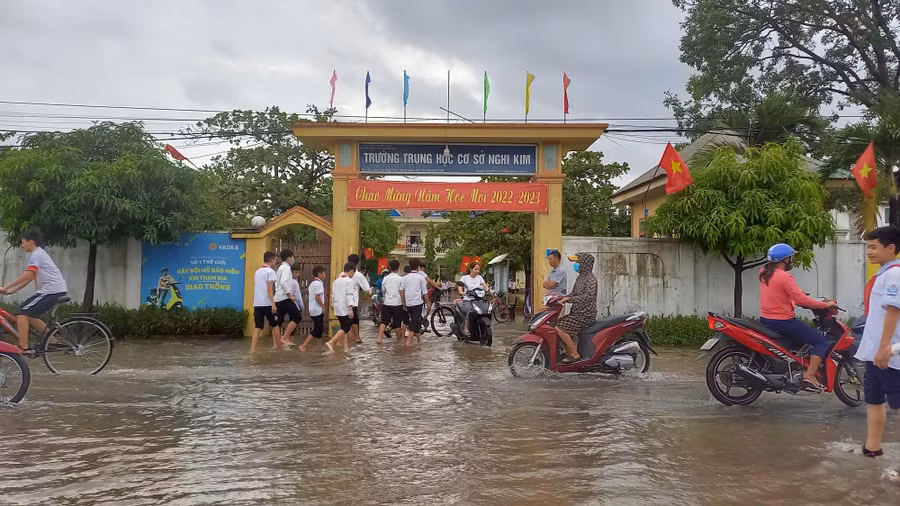 Tại TP Vinh sáng nay học sinh vẫn đến trường bình thường. Tuy nhiên, một số trường ở vùng thấp trũng, thoát nước chậm bị ngập, học sinh lội bộ vào trường.