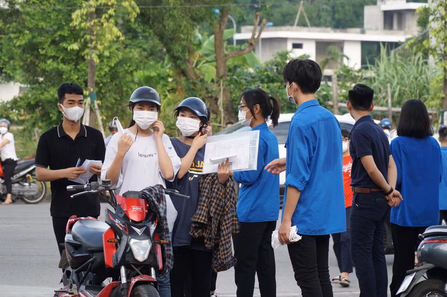 Thí sinh đến sớm được đổi khẩu trang mới trước cổng điểm thi Trường THPT Cửa Lò, Nghệ An.