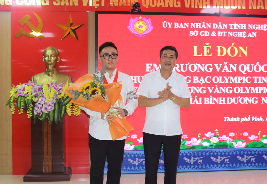 Ông Thái Văn Thành - Giám đốc Sở GD&amp;ĐT Nghệ An chúc mừng và tặng quà cho em Trương Văn Quốc Bảo.