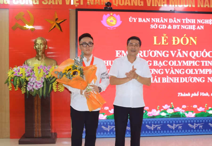 Ông Thái Văn Thành - Giám đốc Sở GD&amp;ĐT Nghệ An chúc mừng và tặng quà cho em Trương Văn Quốc Bảo.