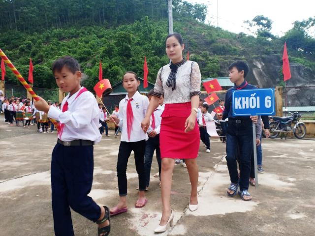 Học sinh khối lớp 6, Trường PTDT bán trú THCS Mường Lý, được cô giáo đón vào trường trong buổi khai giảng năm học mới.