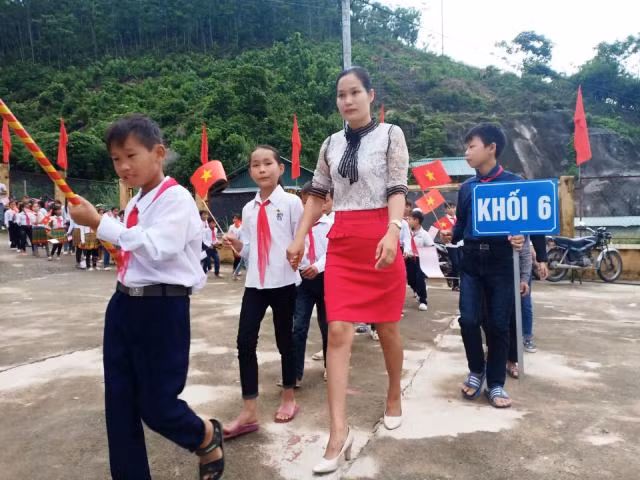 Học sinh khối lớp 6, Trường PTDT bán trú THCS Mường Lý, được cô giáo đón vào trường trong buổi khai giảng năm học mới.