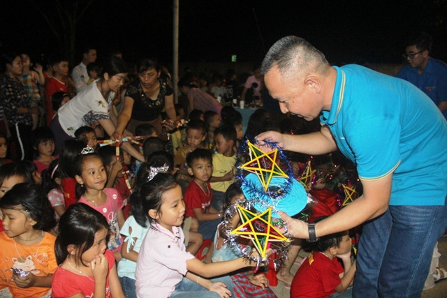 Thành viên đoàn thiện nguyện phát đồ chơi Trung thu cho học sinh.