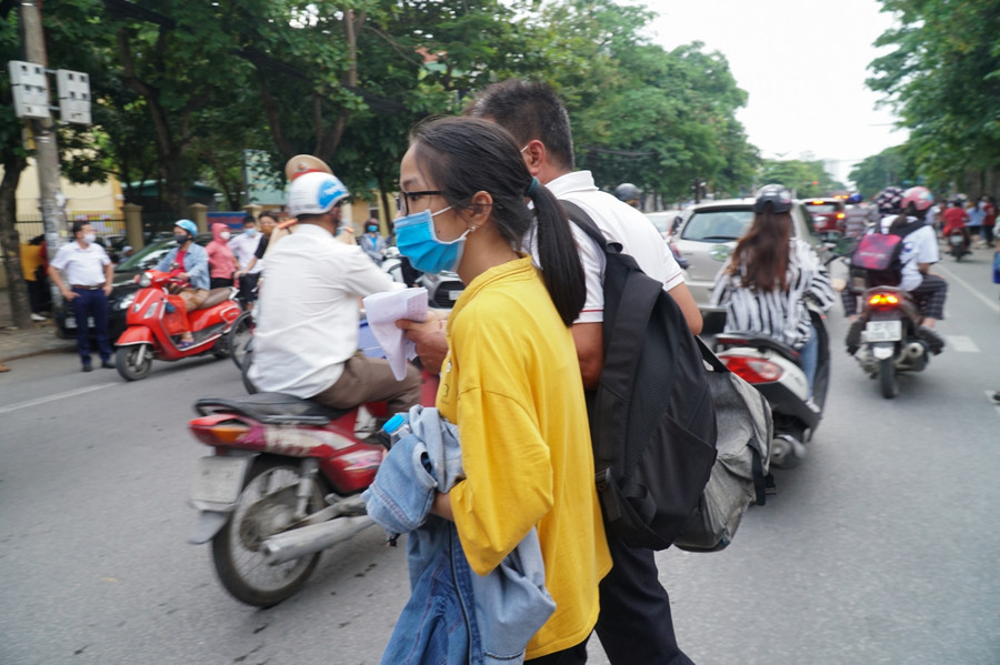 Kỳ thi vào Trường THPT chuyên Phan Bội Châu, có nhiều thí sinh từ khắp các huyện, thị về TP Vinh dự thi. Sau khi hoàn thành nhiệm vụ, người cha 2 vai mang hai balo dắt con gái sang đường để bắt xe trở về nhà.