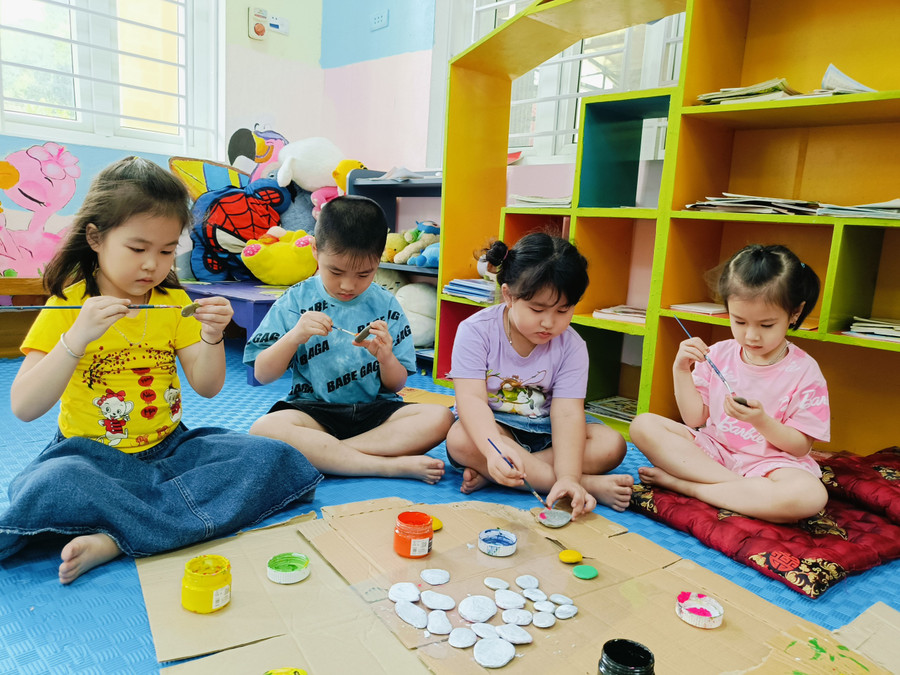 Các bé hỗ trợ, phụ giúp cô giáo bằng việc tô màu lên những viên đá cuội.Ảnh: NTCC Các bé hỗ trợ, phụ giúp cô giáo bằng việc tô màu lên những viên đá cuội.Ảnh: NTCC