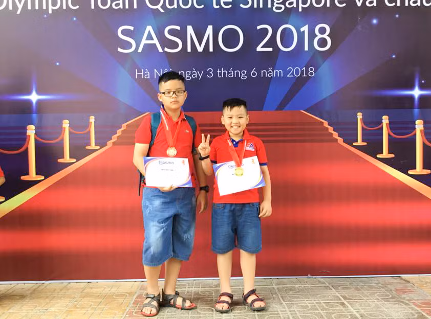 Khánh Gia (bên phải) cùng anh trai Khánh An cùng đạt huy chương trong cuộc thi Olympic Toán Singapore và Châu Á.