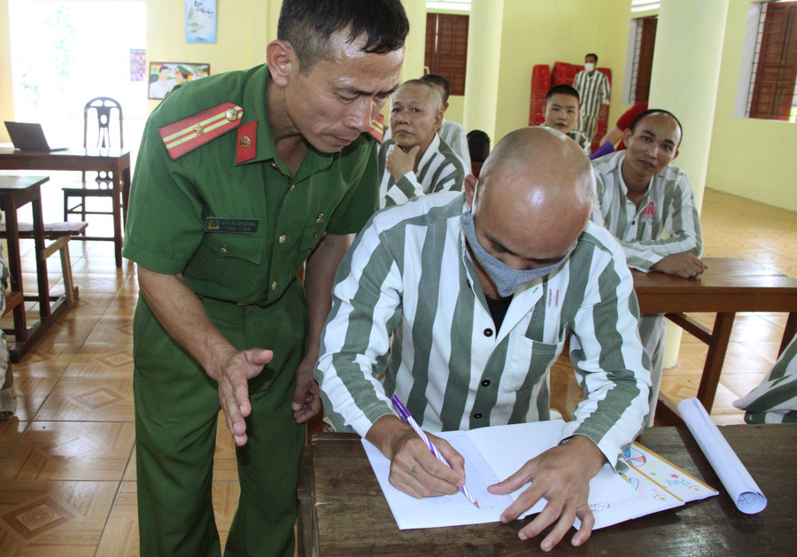 Thiếu tá Nguyễn Bá Đường và học viên trong lớp văn hóa xóa mù chữ. Ảnh: Hồ Lài