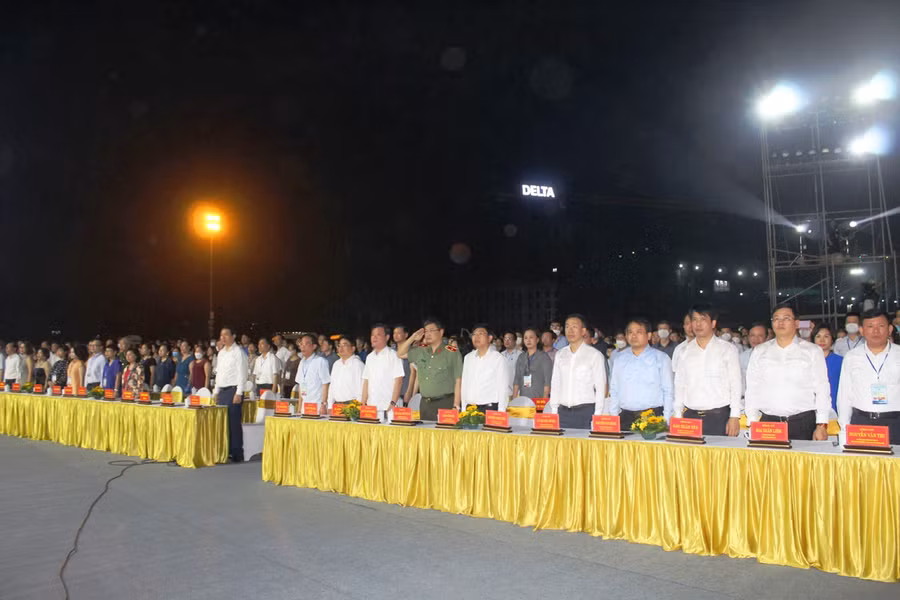 Các đại biểu và người dân thực hiện nghi thức Chào cờ trước khi diễn ra chương trình.