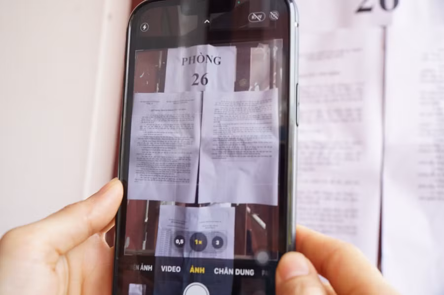 Một phụ huynh cẩn thận chụp lại quy chế thi, các quy định về vật dụng được đem vào phòng thi để nhắc nhở con em mình. Ảnh: Hồ Lài.