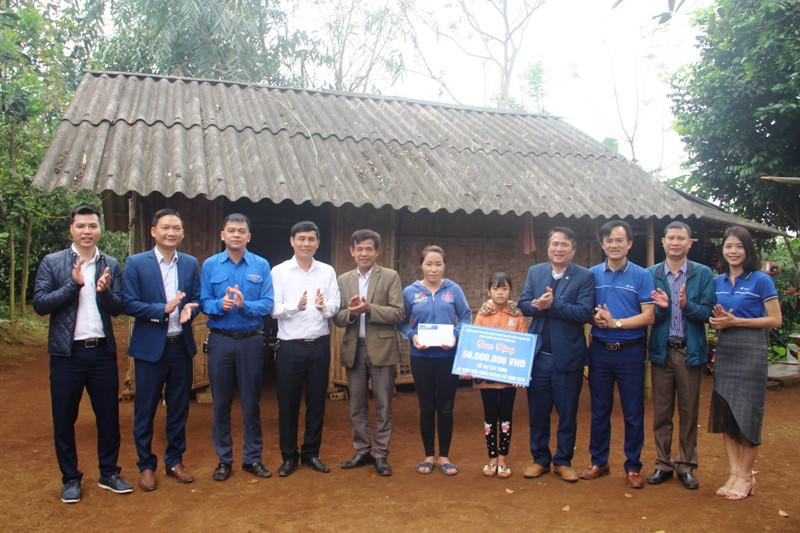 Hai mẹ con em Hoàng Thị Thùy đón nhận tiền hỗ trợ để xây nhà ở.